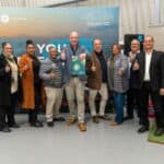 Cape Town news team at an event, group photo with thumbs up, diverse professionals in business attir.