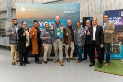 Cape Town news team at an event, group photo with thumbs up, diverse professionals in business attir.