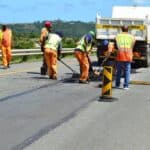 Road repair crew working on asphalt on Cape Town highway.