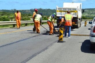 Road repair crew working on asphalt on Cape Town highway.