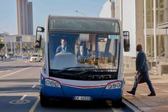 Modern city bus on a busy urban street in Cape Town, South Africa.
