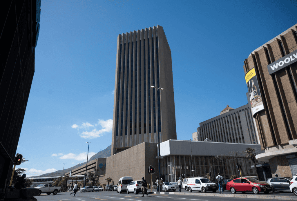A tall modern office building in Cape Town city center under a clear blue sky.