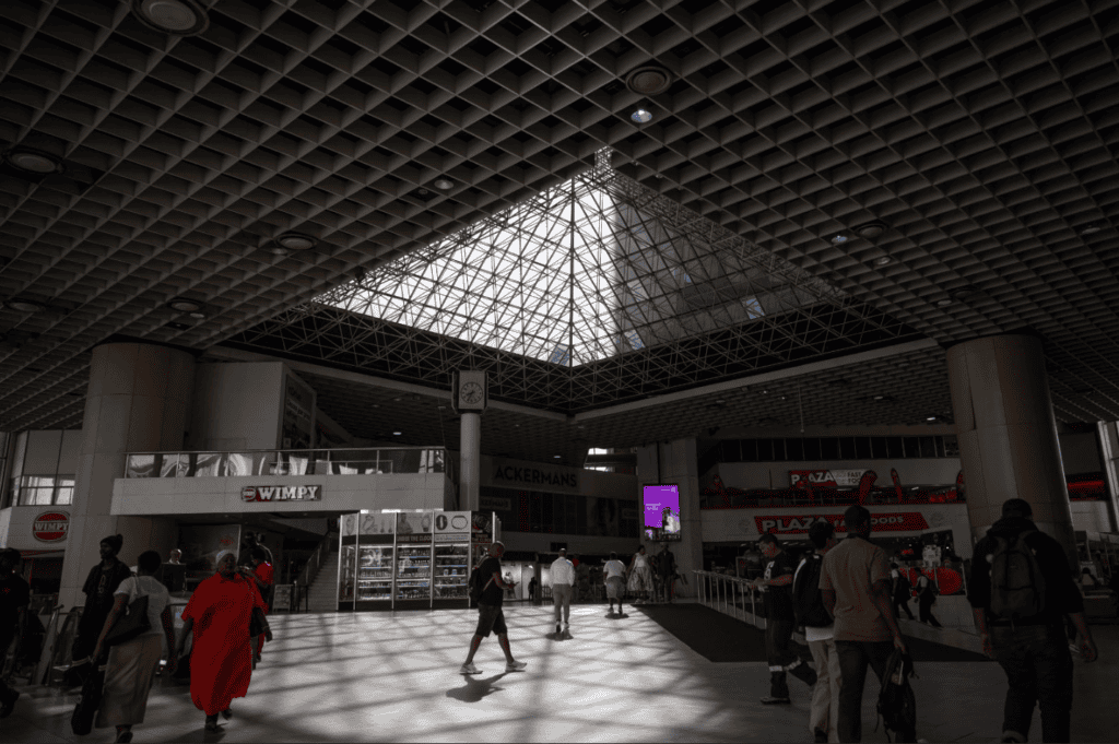 Cape Town train station interior with travelers and modern architecture.