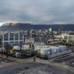 Cape Town harbor with Table Mountain in the background, under cloudy skies.