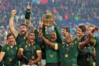 South African rugby team with trophy and medals after winning a major match.